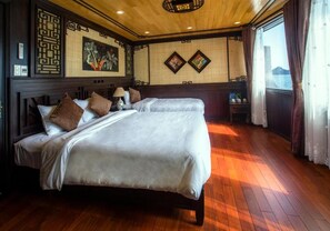 Habitación de hotel con dos camas, suelo de madera y decoración de pared tradicional.