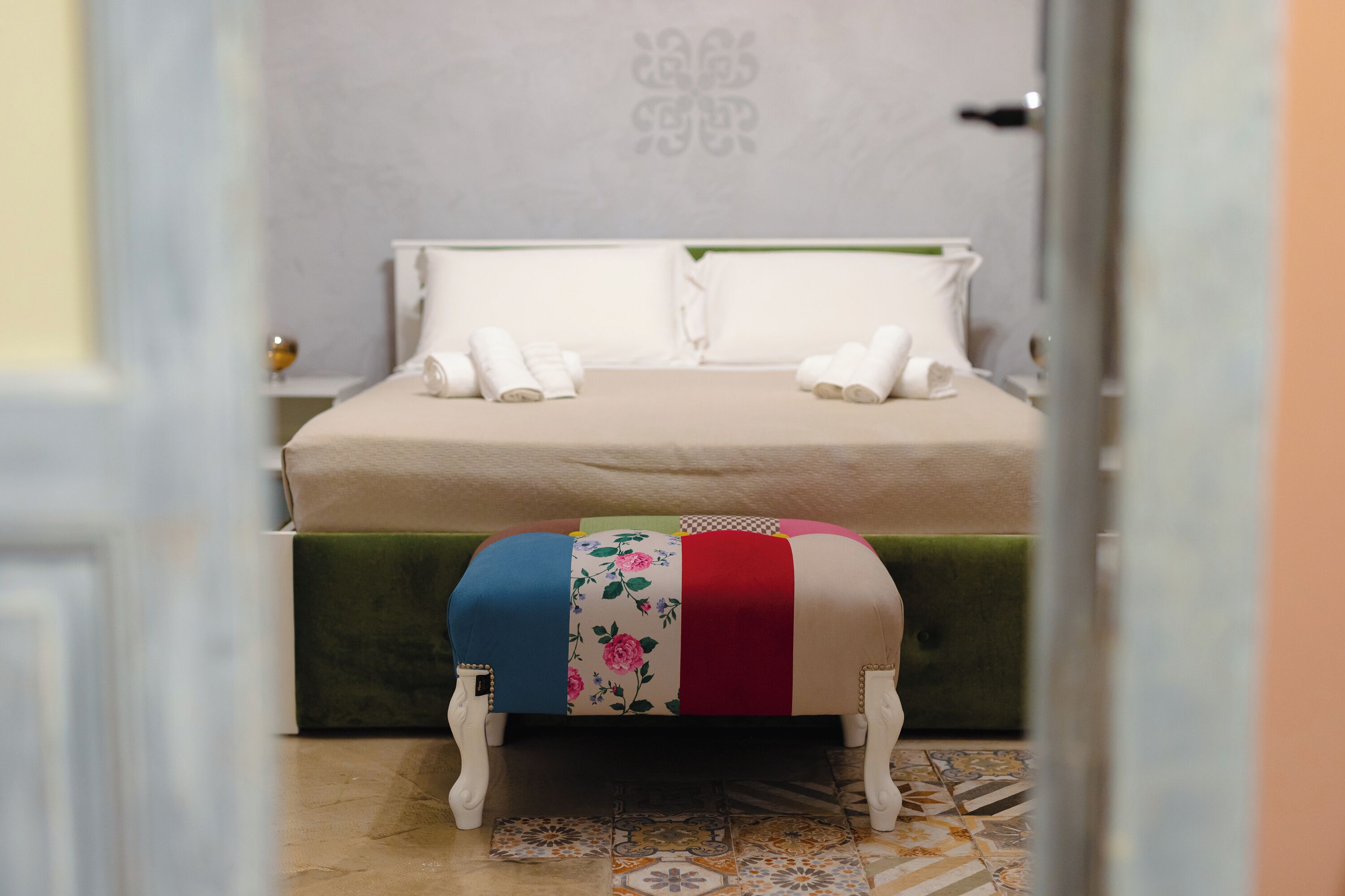 A neatly made bed with two pillows and two folded towels.