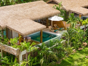 A resort with thatched-roof villas, a swimming pool, and lush tropical vegetation. - Wild Cottages Elephant Sanctuary Resort (Koh Samui)