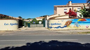 A gated entrance to a property named "Les Agathines" with a mural depicting a beach scene.