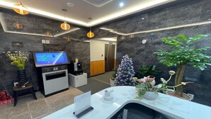 A reception area with a reception desk, a digital display, a security camera, and a Christmas tree. - The Road (Seoul)