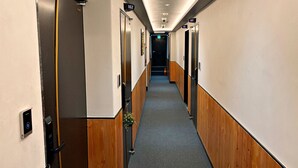 A hotel hallway with doors numbered 101, 102, 106, and 107. - The Road (Seoul)