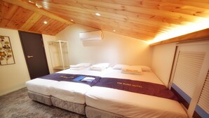 A bedroom with a large bed, a wooden ceiling, an air conditioning unit, and a door. - The Road (Seoul)