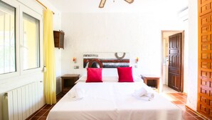 A hotel room with a large bed, a wooden headboard, a painting on the wall, and a wooden door. - Villa with private pool in Denia (Denia)