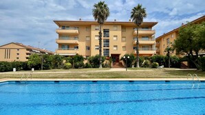 Un hôtel à plusieurs étages avec une piscine en premier plan.