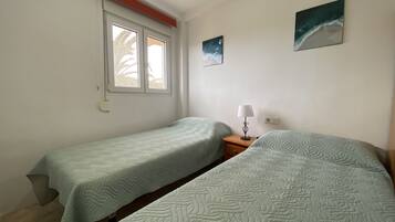 1 dormitorio, tabla de planchar con plancha, ropa de cama