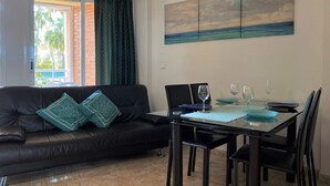A dining area with a black leather sofa, a glass dining table, and black chairs. - MED 19 with paddel court (Denia)
