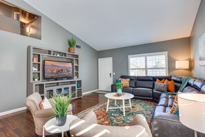 A living room with a flat-screen TV, a sofa, a coffee table, and a fireplace. - Heated Pool.  3 King Rooms! Sleeps 9! (Glendale)