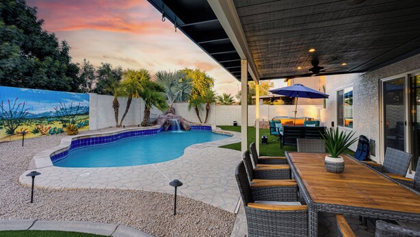 A backyard with a swimming pool, patio furniture, and a waterfall feature. - 4BR w pool, fire pit, 3 king rooms (Glendale)