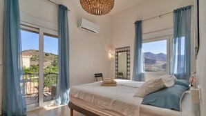 Une chambre à coucher comprenant un lit, une table de chevet, une lampe, une fenêtre donnant sur l’extérieur et un appareil de climatisation.