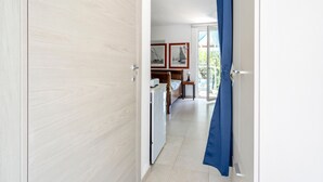 A hallway leading to a bedroom with a bed, a desk, and a window. - Villa Massa Depandance Apartment with Sea View, Wi-Fi and Air Conditioning (Polignano a Mare)