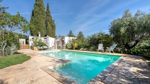 A swimming pool with a stone deck, surrounded by greenery and tall trees. - Apartment 'Villa Massa' with Sea View, Wi-Fi and Air Conditioning (Polignano a Mare)