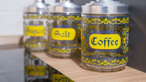 Drei transparente Gläser mit Metalldeckeln, beschriftet mit Kaffe, Salz und Pfeffer.