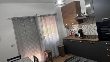 Eine kleine Küche mit Essbereich, einem Mülleimer und einem Teppich.