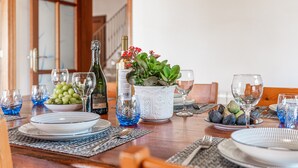 A dining table set with plates, glasses, a bottle, and a potted plant. - Villa 'Can Rito Nou' with Mountain View, Wi-Fi and Air Conditioning (Felanitx)