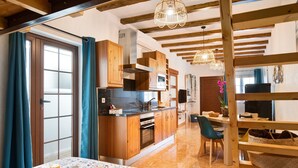 A kitchen with wooden cabinets, a central island, and a dining area with a table set for breakfast. - Holiday Home 'El Rinconcito De Jess' with Wi-Fi and Air Conditioning (El Golfo)
