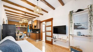A modern interior with a bed, kitchen, TV, and a view of the sea. - Holiday Home 'El Rinconcito De Jess' with Wi-Fi and Air Conditioning (El Golfo)