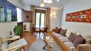 A living room with a sofa, a glass coffee table, a dining table with chairs, a potted plant, and a fire extinguisher. - Pool, BBQ, 7 min drive to the beach on an avocado & mango estate, 15 min from Málaga center (Málaga)
