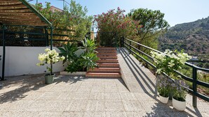 A staircase with a metal railing, surrounded by potted plants and flowers, leading to a building with a white exterior. - Pool, BBQ, 7 min drive to the beach on an avocado & mango estate, 15 min from Málaga center (Málaga)