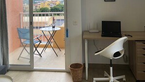 A modern room with a balcony, a desk with a laptop, a chair, and artwork on the wall. - Apartment 'Aguila 900' with Private Terrace, Wi-Fi, and Air Conditioning (Benalmadena Arroyo de la Miel)