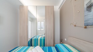 Quarto com cama, espelho e decoração de parede em tela mosquiteira.