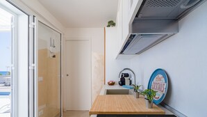 A compact kitchen with a wooden countertop, a coffee machine, a sink, and a potted plant. - Holiday Apartment "Greta Vista Mare" with Sea View, Private Terrace & Wi-Fi (Lido di Noto)