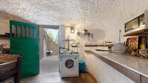 Cocina compacta con lavadora, microondas y lavabo.