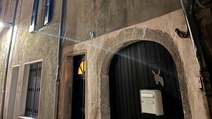 Un immeuble à plusieurs étages, doté d’arcades et d’une enseigne indiquant le numéro 16.