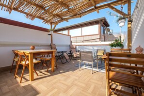 An outdoor patio with wooden furniture, a table, and a hanging plant. - Holiday Home 'Mira' accomodation with a terrace. (Spadafora)