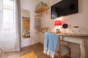 A room with a TV, wooden furniture, a mirror, a red lamp, and a view of the outside. - Holiday Home 'Mira' accomodation with a terrace. (Spadafora)