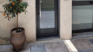 A building entrance with a potted plant, a door, and a wall-mounted device. - Holiday Home 'Mira' accomodation with a terrace. (Spadafora)
