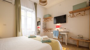 A hotel room with a bed, a desk, a chair, a television, and a window with curtains. - Holiday Home 'Mira' accomodation with a terrace. (Spadafora)