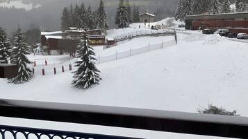 Eine verschneite Landschaft mit einem Gebäude und Bäumen.