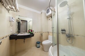 Une salle de bain équipée d’un lavabo, d’un miroir, de toilettes et d’une douche.
