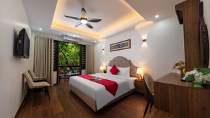 A modern hotel room with a large bed, a desk, a chair, and a ceiling fan. - Hanoi Liliane Hotel and Travel (Hanoi)