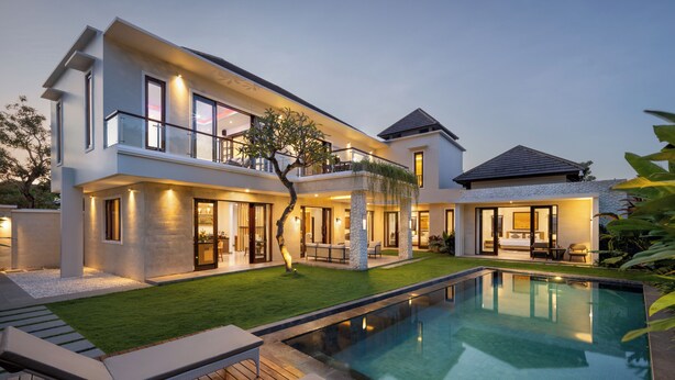 A modern two-story house with a swimming pool, outdoor seating, and a well-maintained lawn. - Villa UmaDahayu (Denpasar)