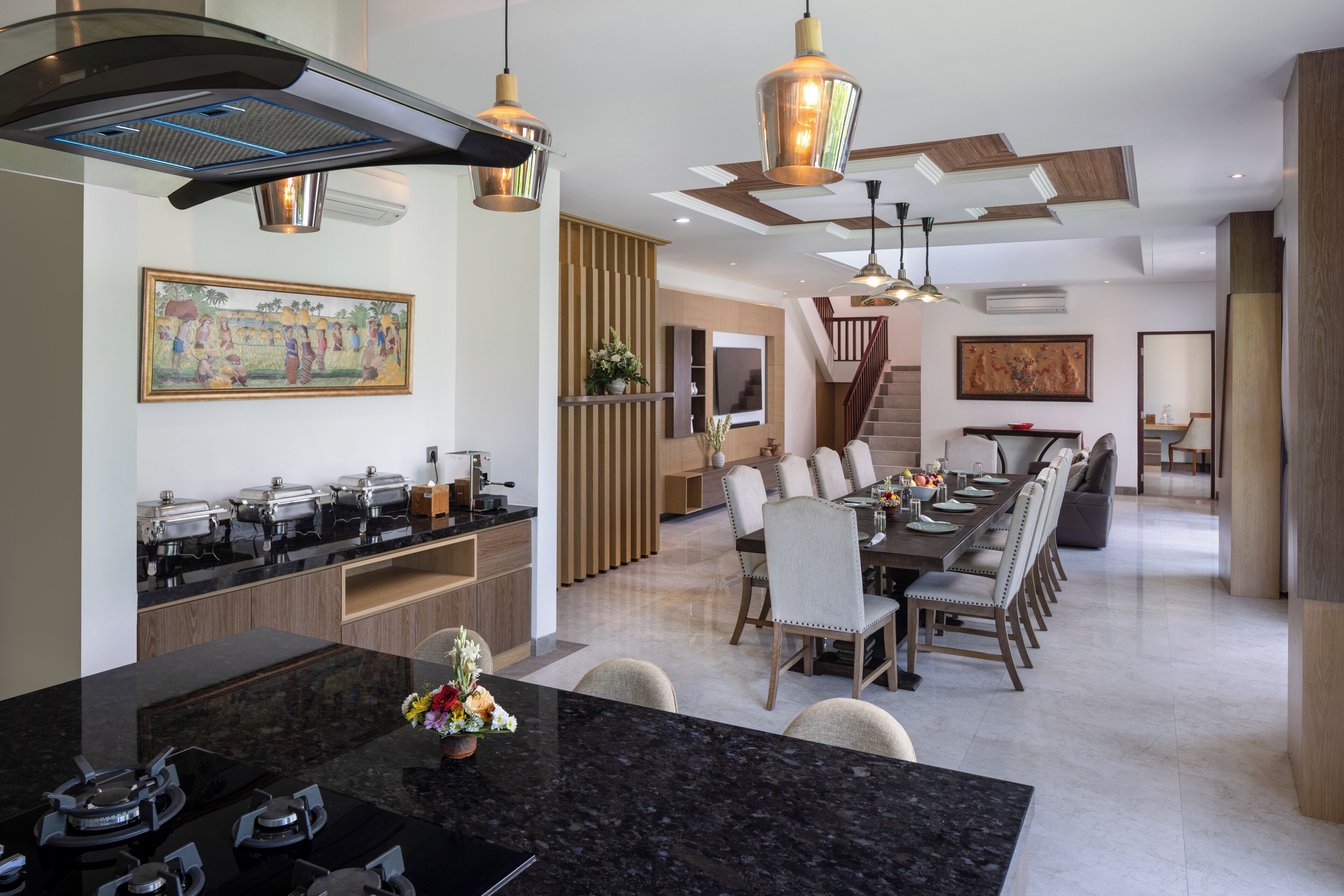 A modern kitchen with a central island, built-in appliances, and pendant lighting.