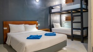 A hotel room with a bunk bed, a single bed, and a nightstand. - Leisure Hostel (Krabi)
