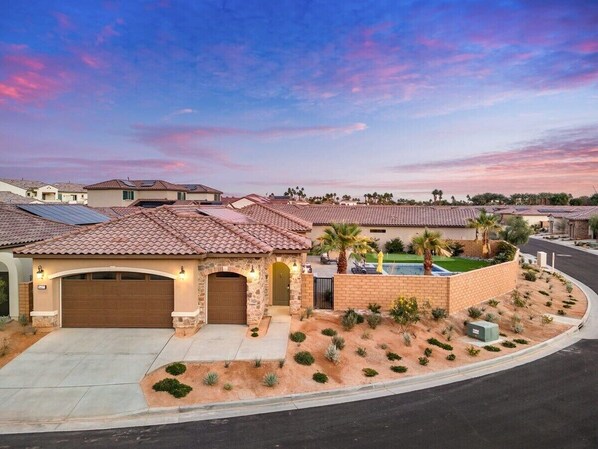 A residential house with a garage, a swimming pool, and a landscaped garden. - Luxurious retreat in La Quinta with mountain views and private pool. (La Quinta)