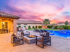 A patio area with outdoor furniture, a fire pit, and a swimming pool.