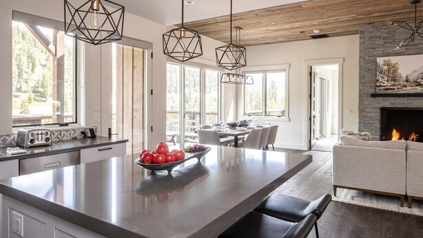 Una cocina moderna con una isla central, ventanas amplias y una chimenea.