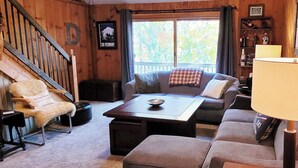 A cozy living room with a sofa, a coffee table, a lamp, and a chair.