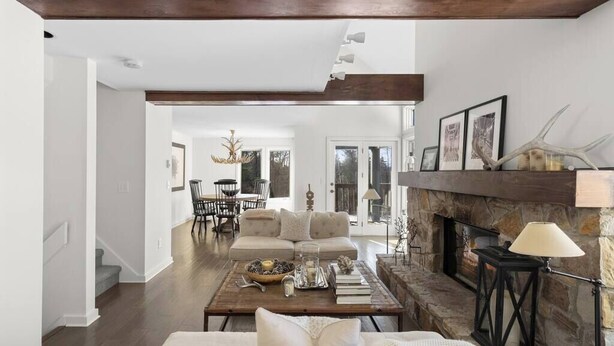 A spacious living room with a fireplace, a coffee table with books and candles, and a sofa. - Updated Condo Close to Mt Snow! (Wilmington)