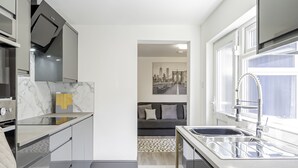 A modern kitchen with a built-in oven, a microwave, and a stainless steel sink.