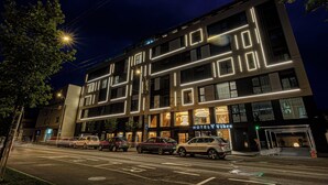 A modern hotel with a prominent 'HOTEL Vibre' sign, featuring a contemporary design with illuminated lines and large windows. - Vibre Hotel (Cluj-Napoca)