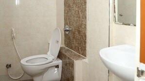 A bathroom with a toilet, sink, and shower. - Shoba Comfort (Bengaluru)