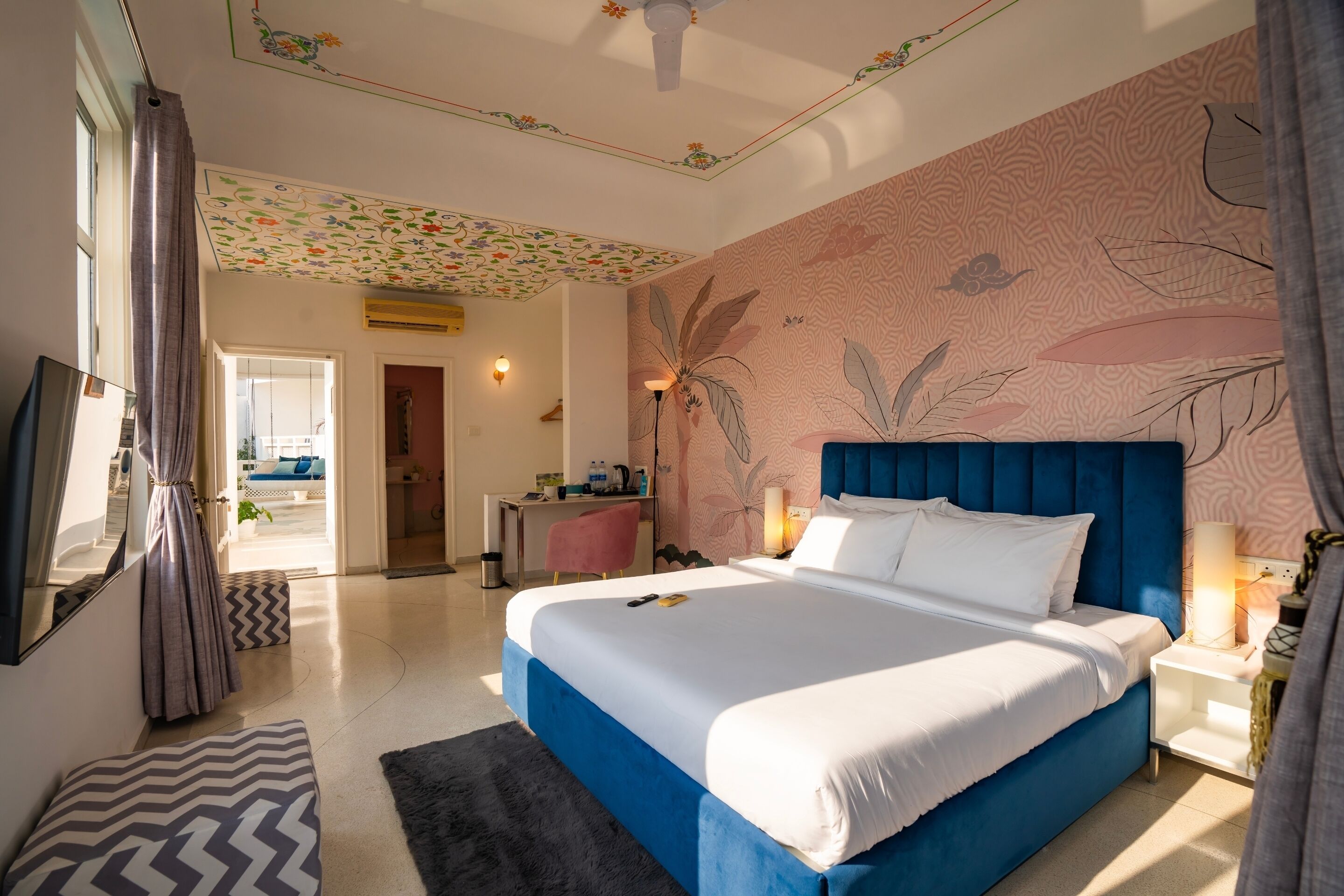 A bedroom with a large bed, a desk, and a chair.