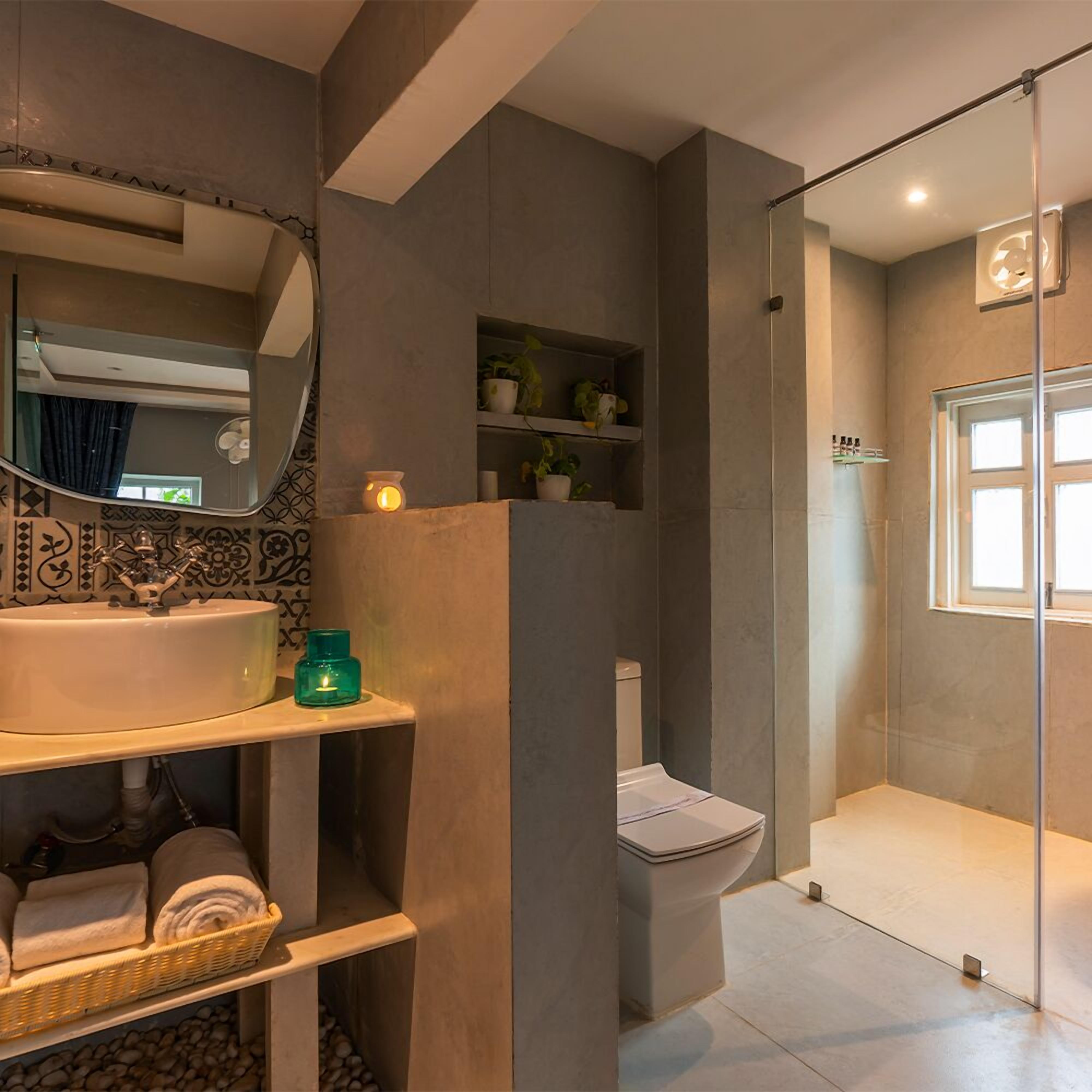 Une salle de bain moderne avec un grand lavabo, un miroir et une douche à parois de verre.