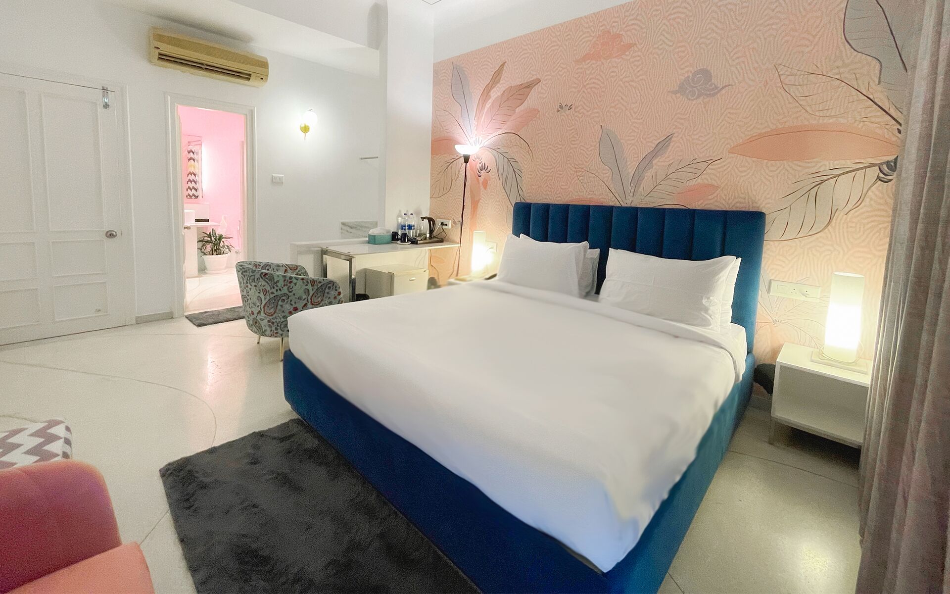 A modern hotel room with a large bed, a desk, and a chair.