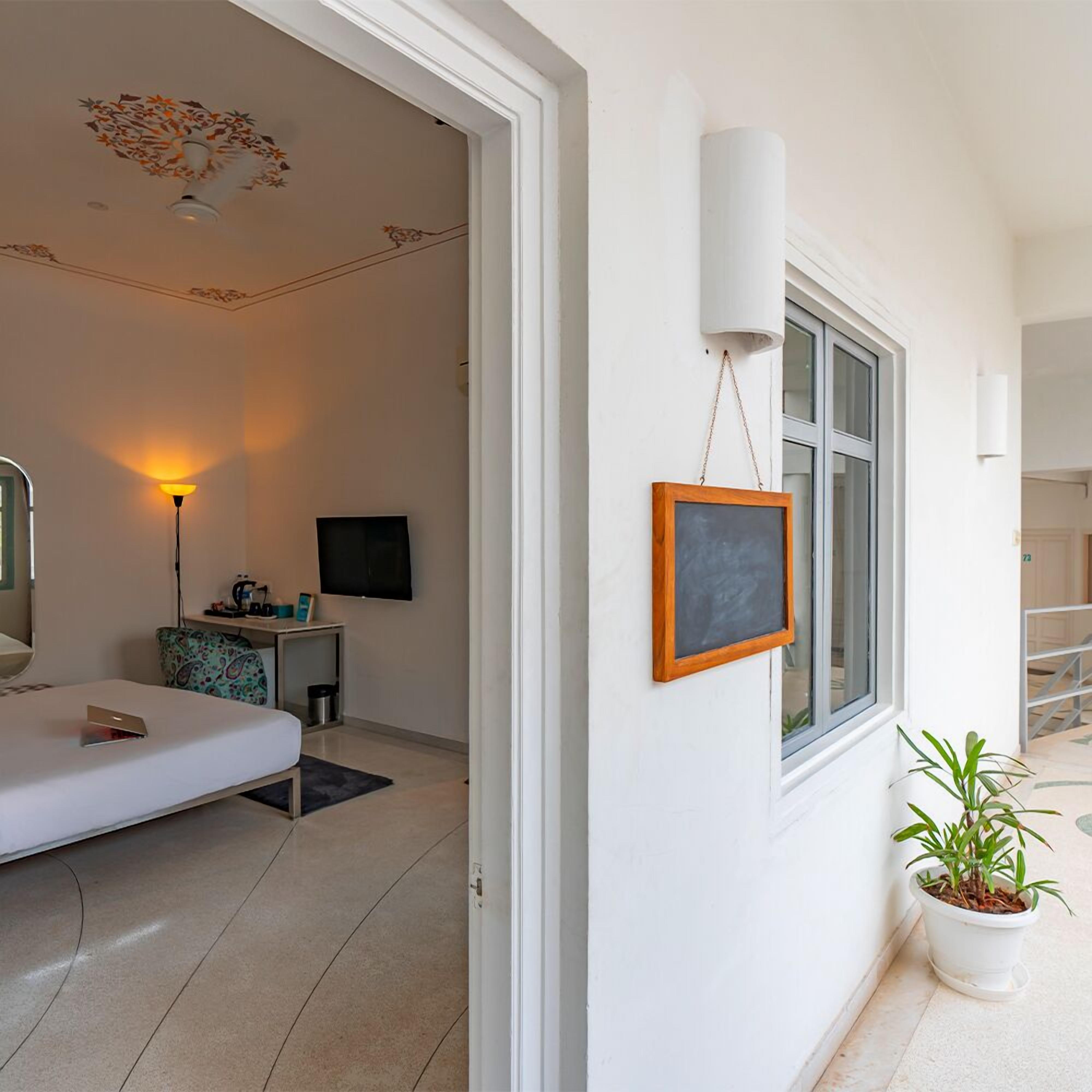 Ein modernes Schlafzimmer mit Bett, Nachttisch, Lampe und Fernseher.